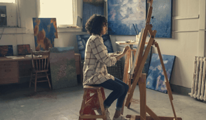 Woman painitng at easel 